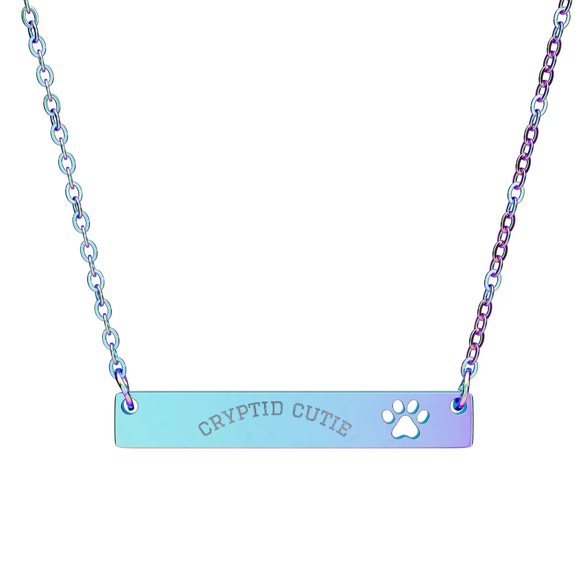 Necklace with 'CRYPTID CUTIE' and paw print on a gradient blue and purple bar, on a white background.