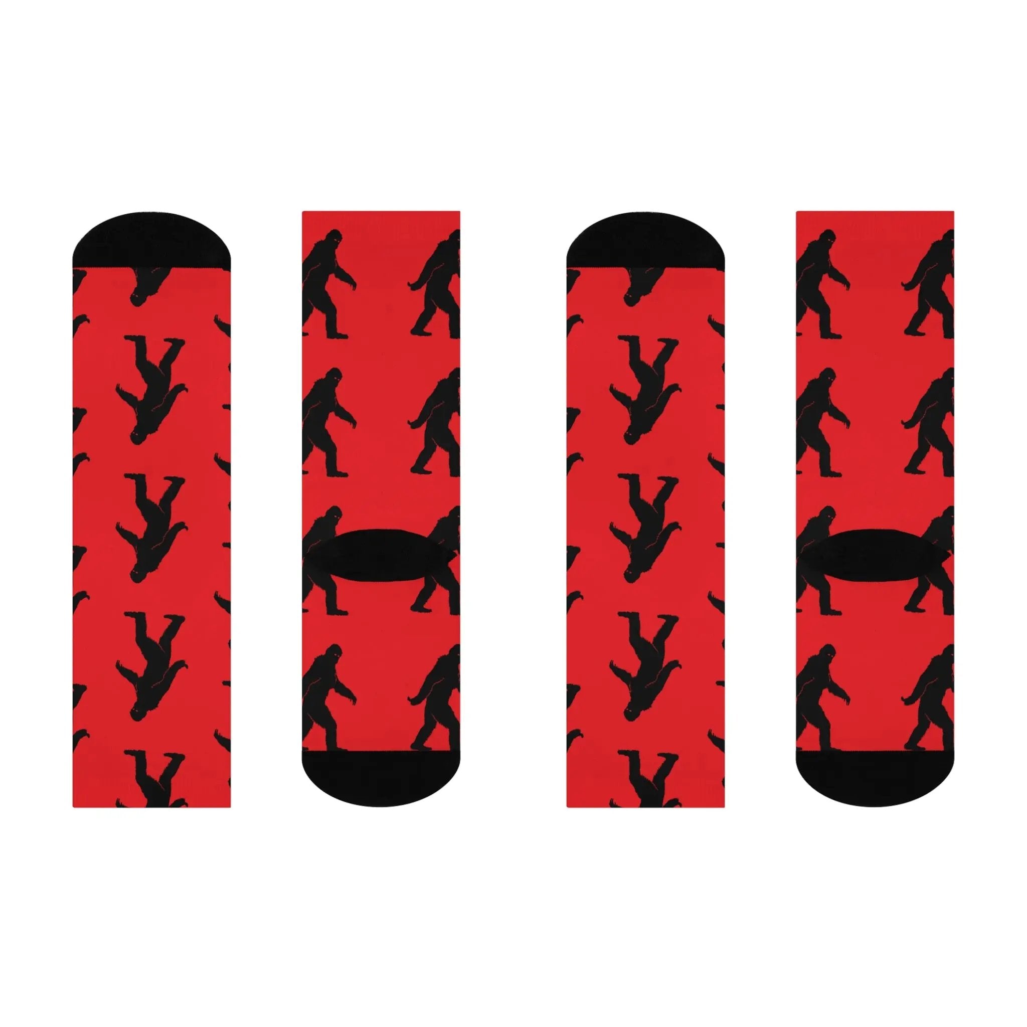 Two pairs of socks with red backgrounds and black bigfoot silhouette designs on a white background