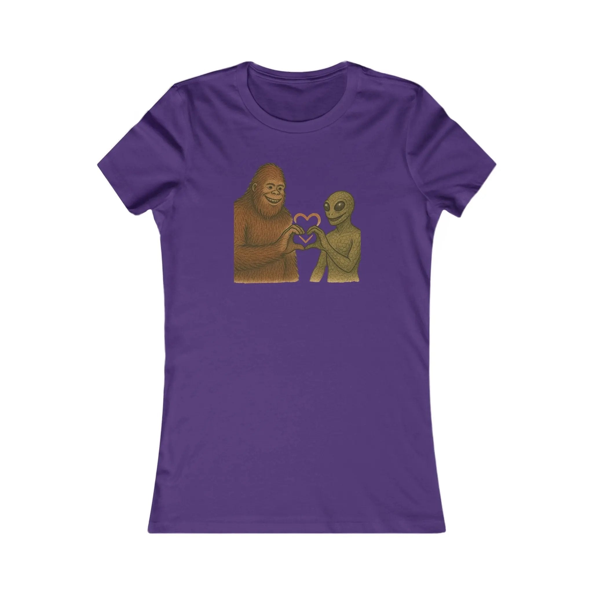 Purple t-shirt with a graphic of a bigfoot and an alien holding hands making a heart symbol on a white background