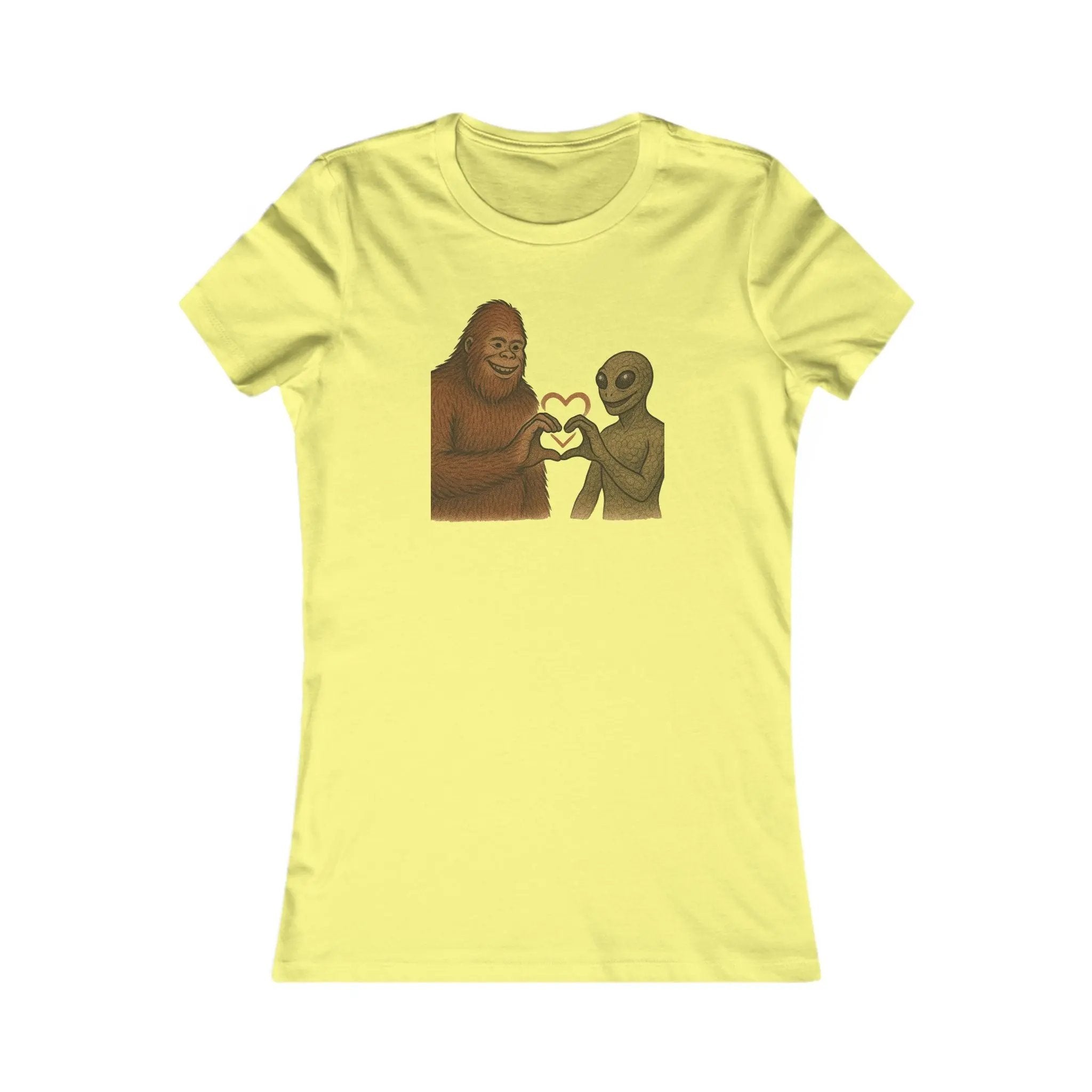 Yellow t-shirt with a graphic of a bigfoot and an alien holding hands making a heart symbol on a white background