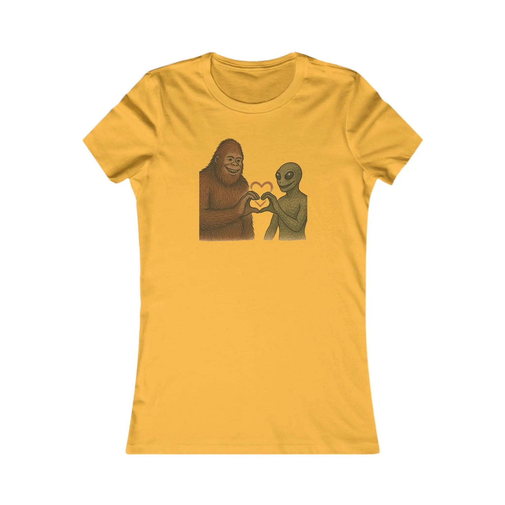 Gold colored t-shirt with a graphic of a bigfoot and an alien holding hands making a heart symbol on a white background