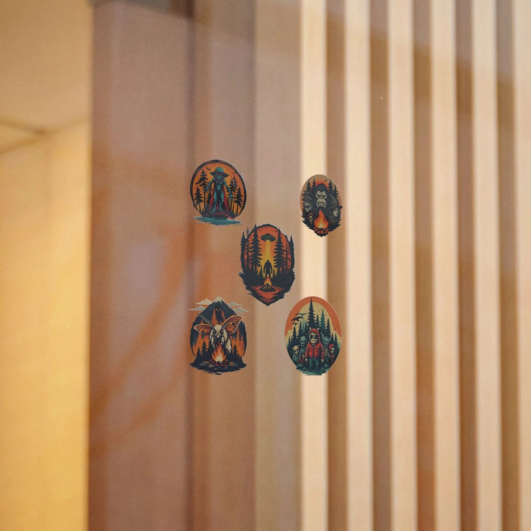 Five illustrated stickers on a window with a beige curtain in the background