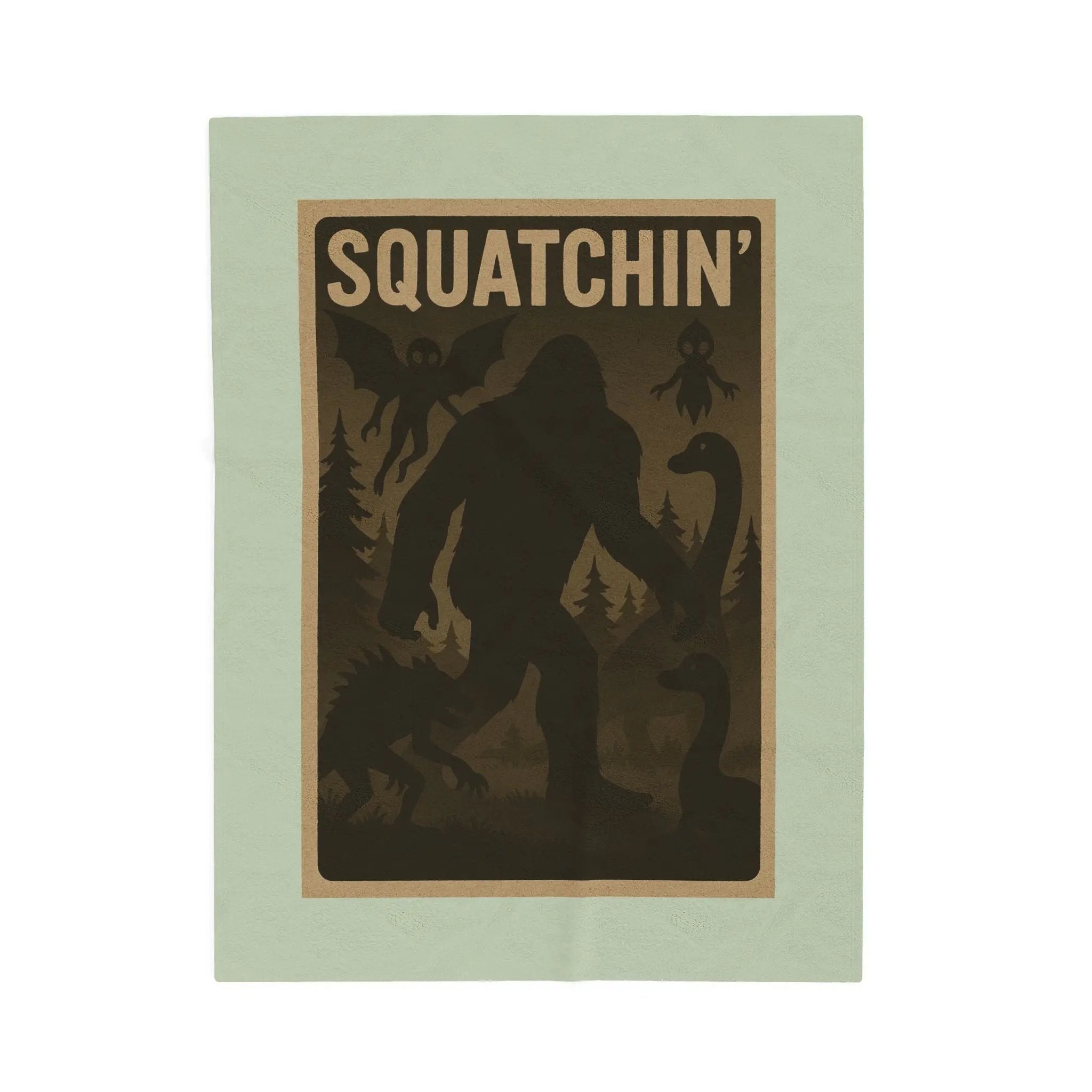 Light green fleece blanket with 'Squatchin' text across the top with silhouettes of bigfoot, loch Ness, werewolf, mothman, and an alien.