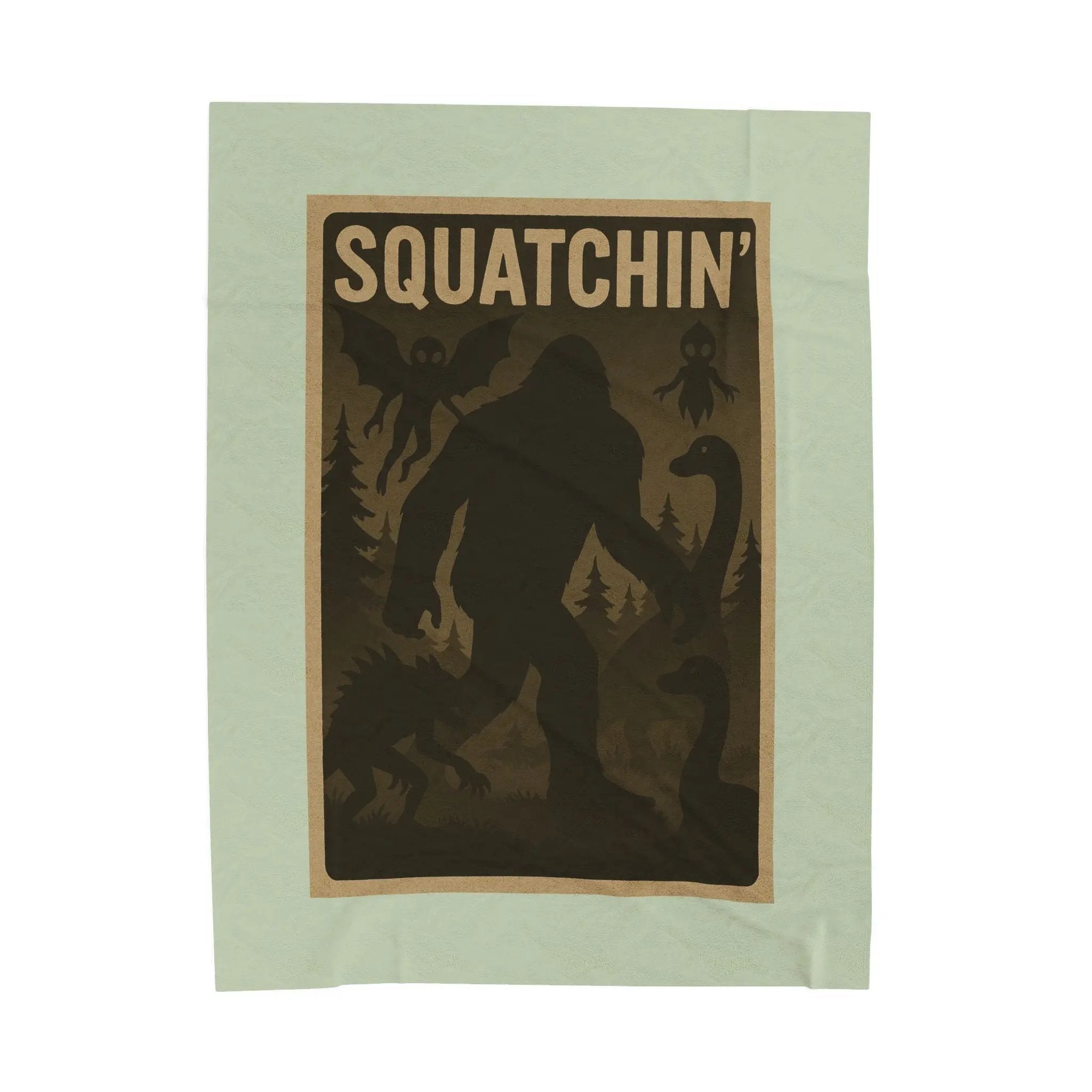 Light green fleece blanket with 'Squatchin' text across the top with silhouettes of bigfoot, loch Ness, werewolf, mothman, and an alien.