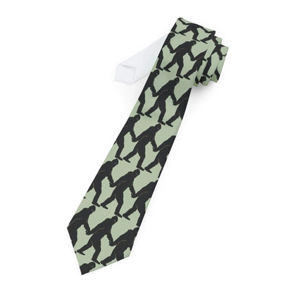 Tie with black bigfoot silhouette pattern on a light green background