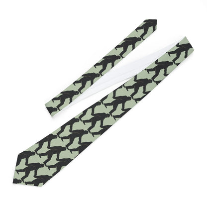 Necktie with black bigfoot silhouette pattern on a light green background