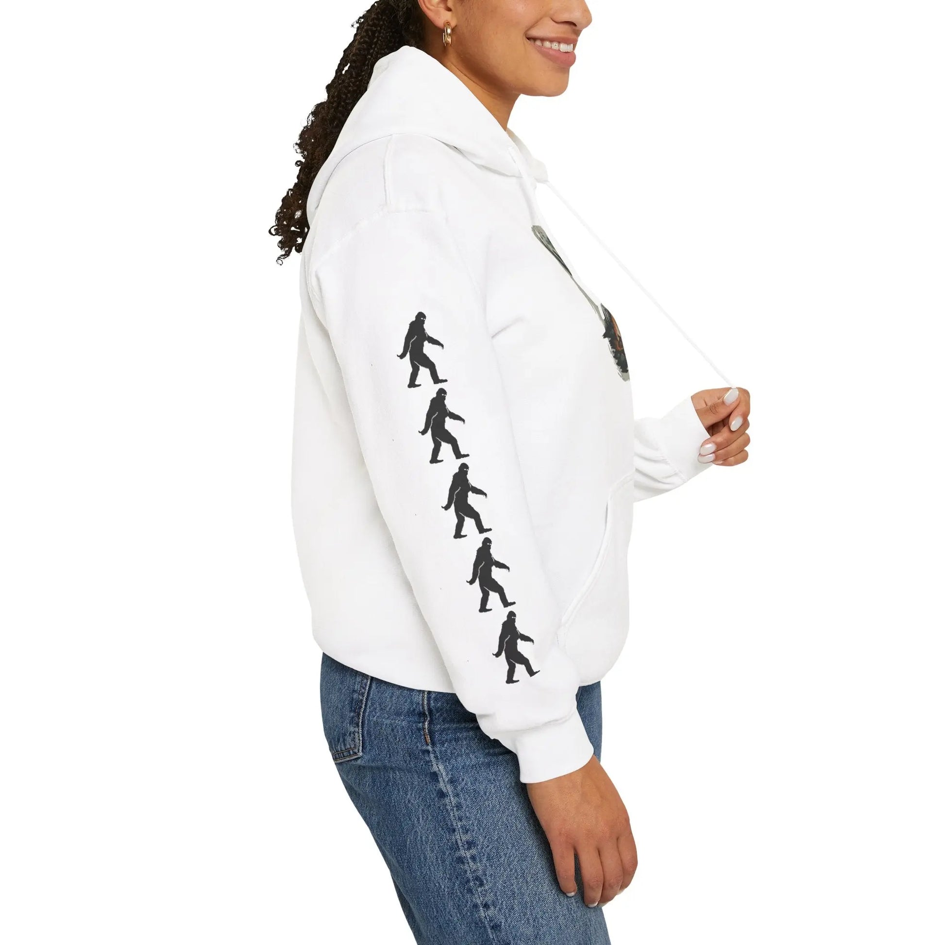 Person wearing a white hoodie with black bigfoot silhouette designs on the right sleeve against a white background