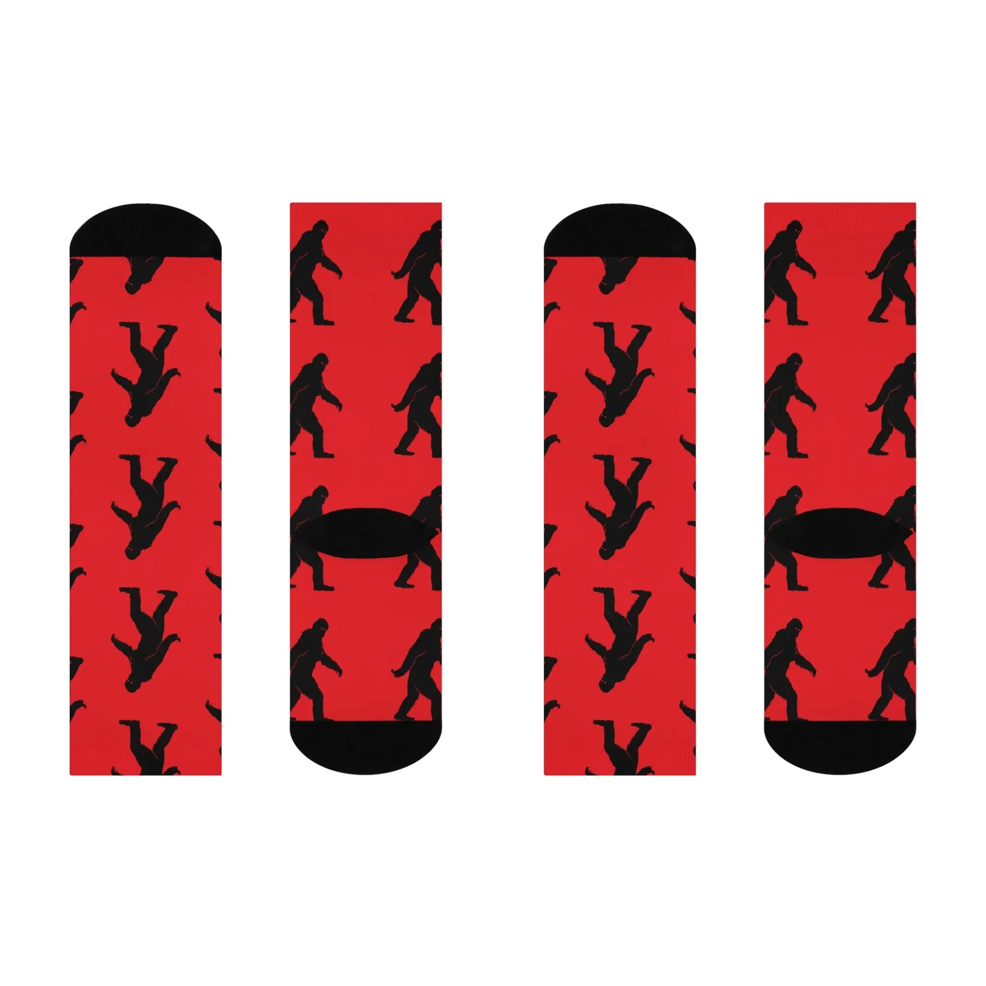 Two pairs of socks with red backgrounds and black bigfoot silhouette designs on a white background