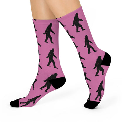 Pink socks with black bigfoot silhouette pattern of a person on a white background
