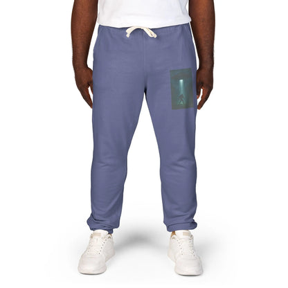 Person wearing blue jogger pants with a small graphic of a UFO with a beam of light on a bigfoot silhouette on the left leg on a white background