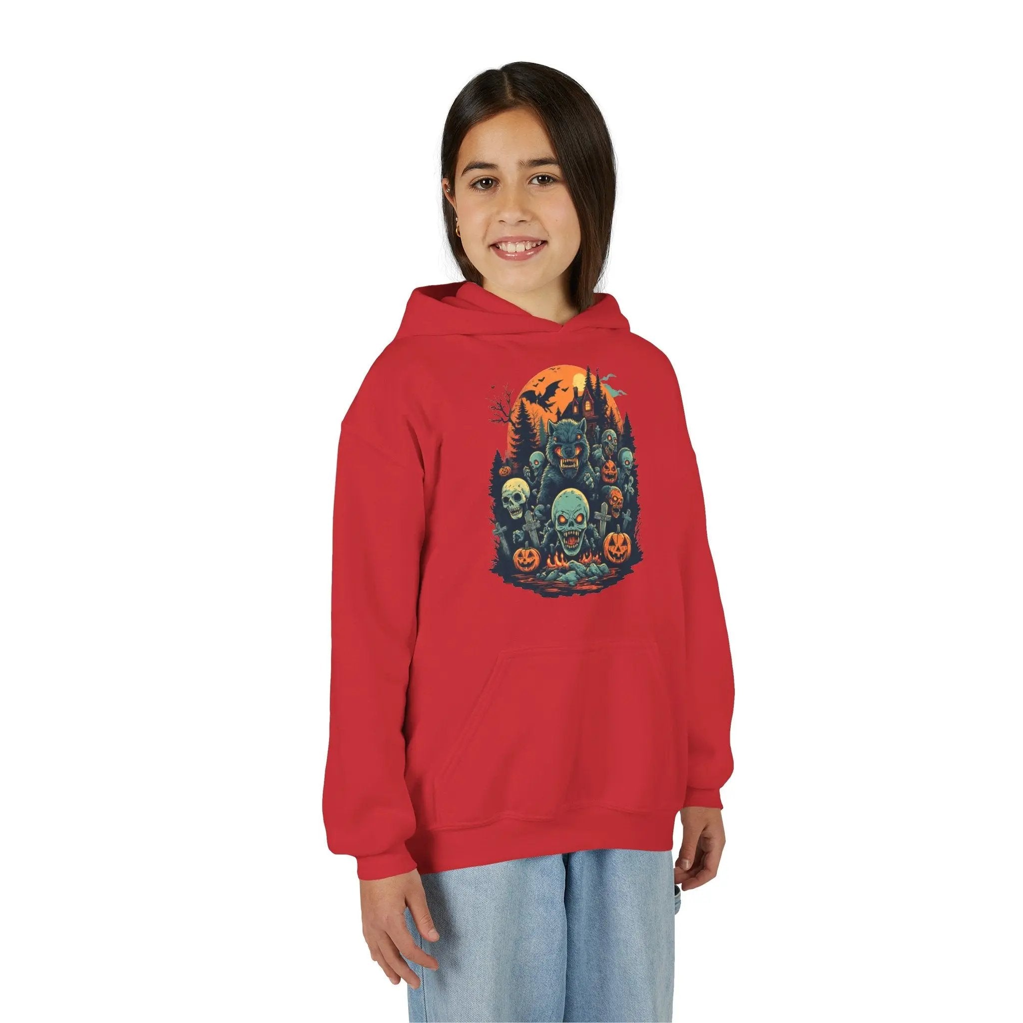 Older child wearing a red hoodie with a colorful Halloween graphic design of werewolves, zombies, and other cryptids on a white background