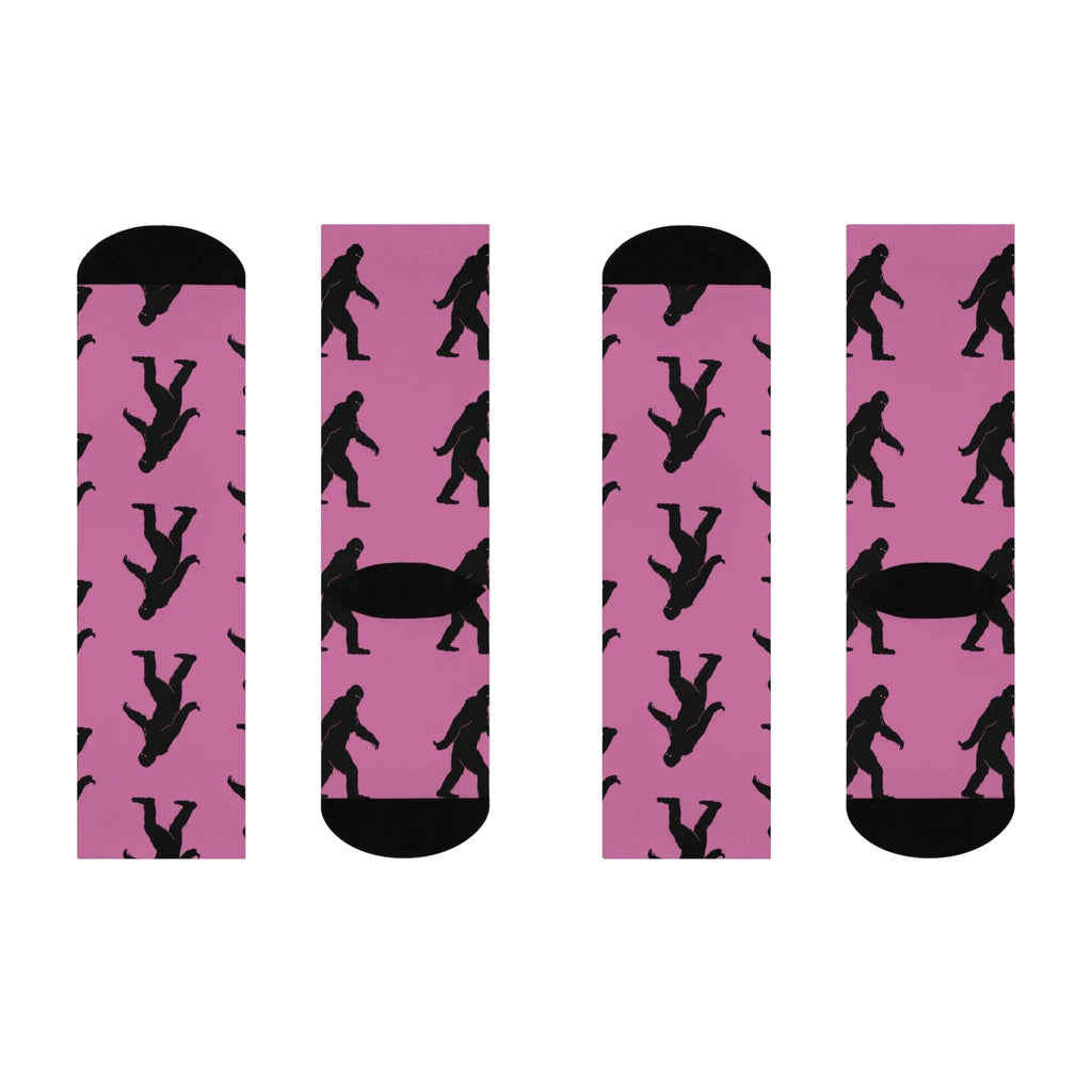 Two pairs of pink socks with black bigfoot silhouette pattern on a white background