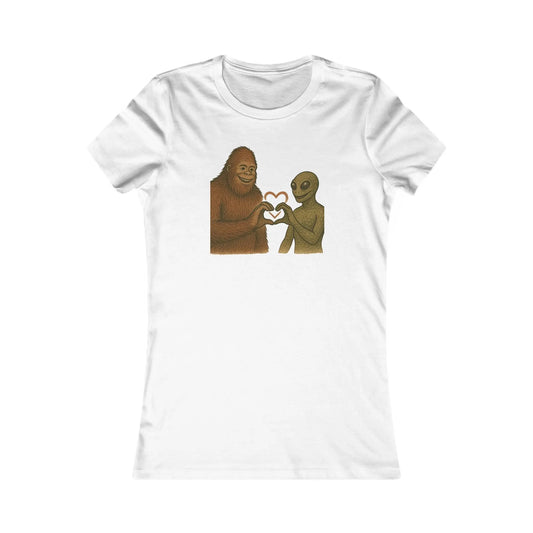 White t-shirt with a graphic of a bigfoot and alien holding hands with a heart symbol on a white background.