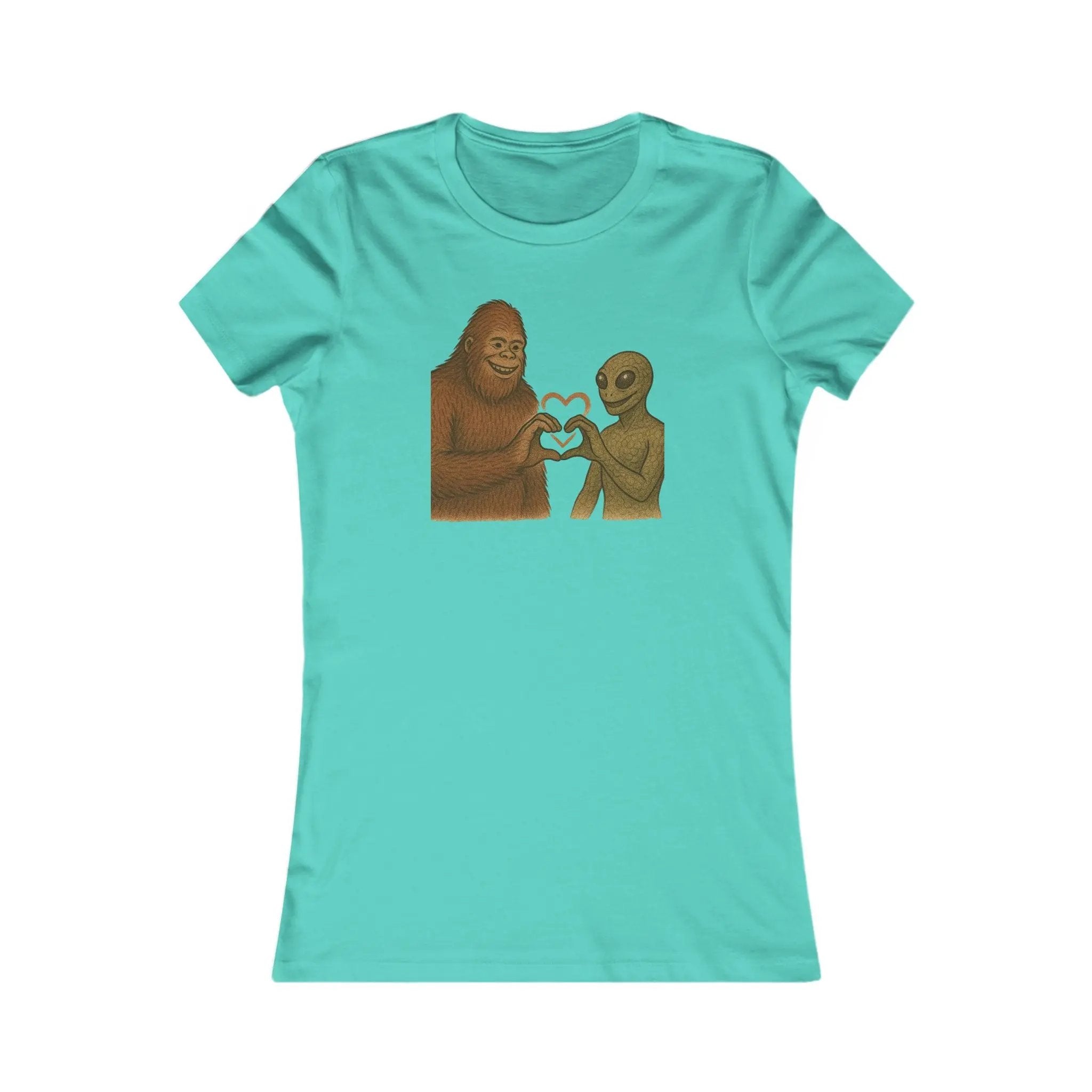 Turquoise t-shirt with a graphic of a bigfoot and an alien holding hands making a heart symbol on a white background