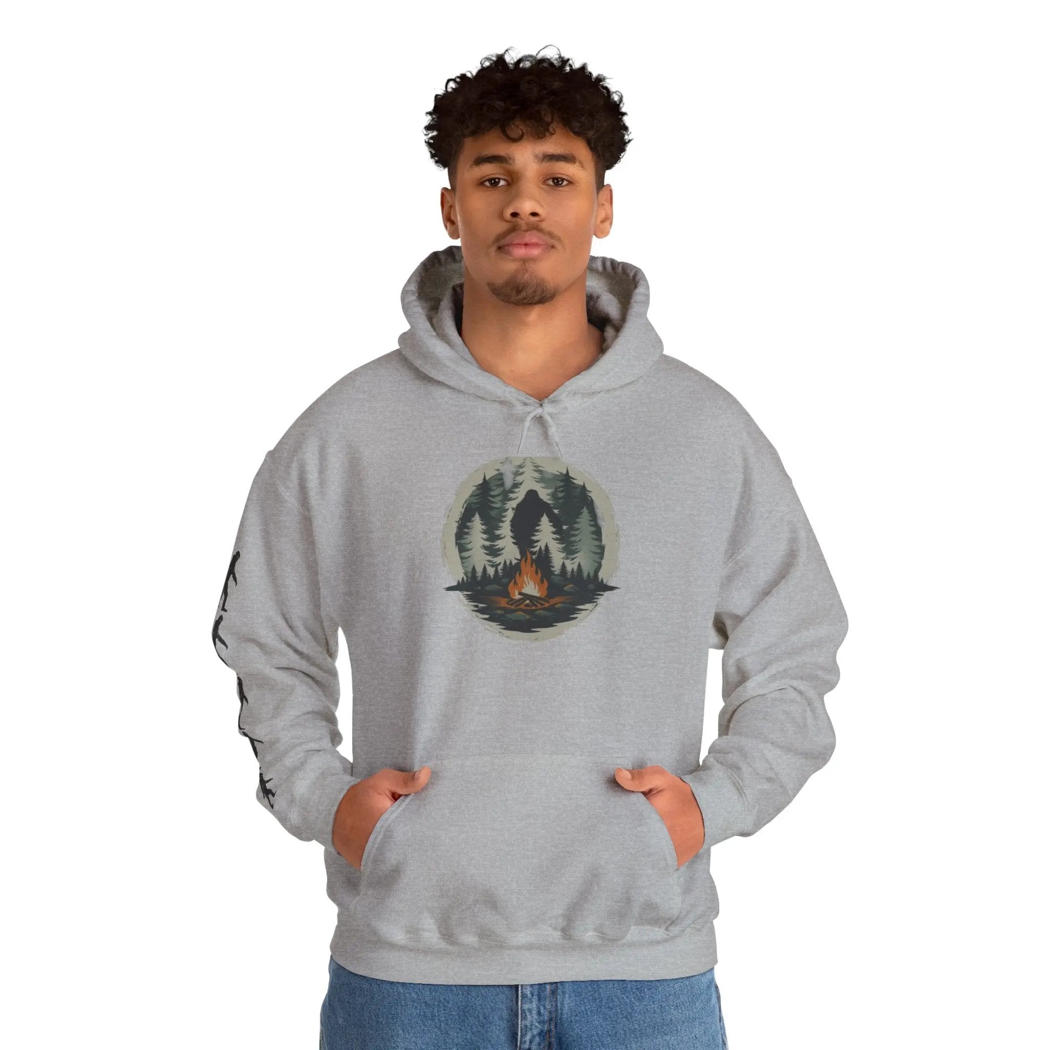 Person wearing a gray hoodie with a nature graphic and black bigfoot silhouettes on the right sleeve on a white background on a white background