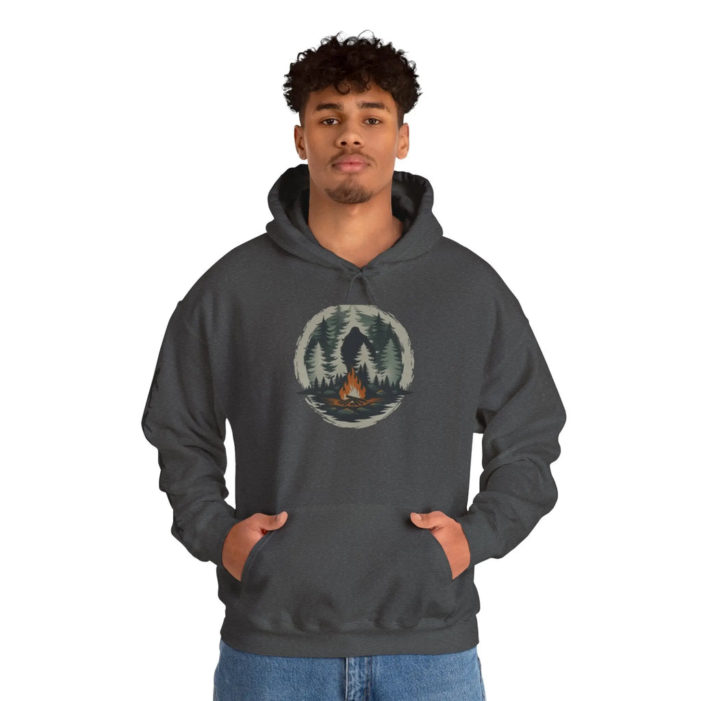Person wearing a dark gray hoodie with a forest design and black bigfoot silhouettes on the right sleeve on a white background on a white background
