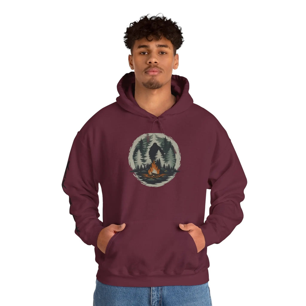 Person wearing a maroon hoodie with a nature graphic and black bigfoot silhouettes on the right sleeve on a white background on a white background