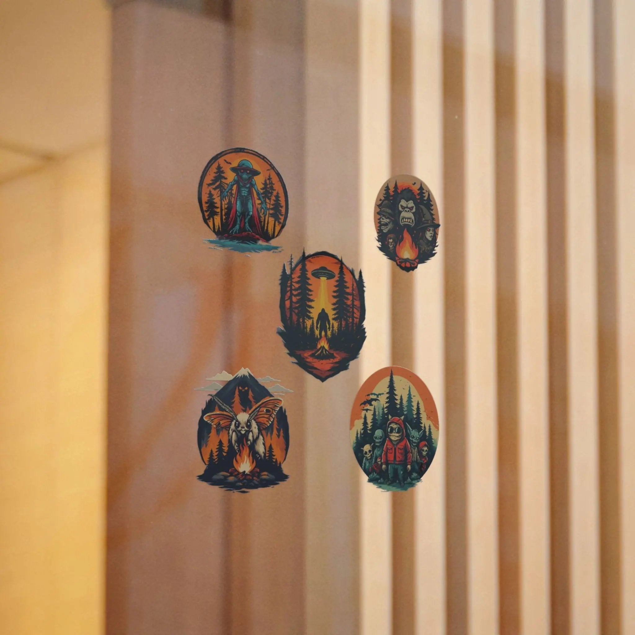 Five illustrated stickers on a window with a beige curtain in the background