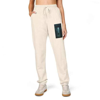 Beige sweatpants with a small graphic of a UFO with a beam of light on a bigfoot silhouette on the left leg on a white background