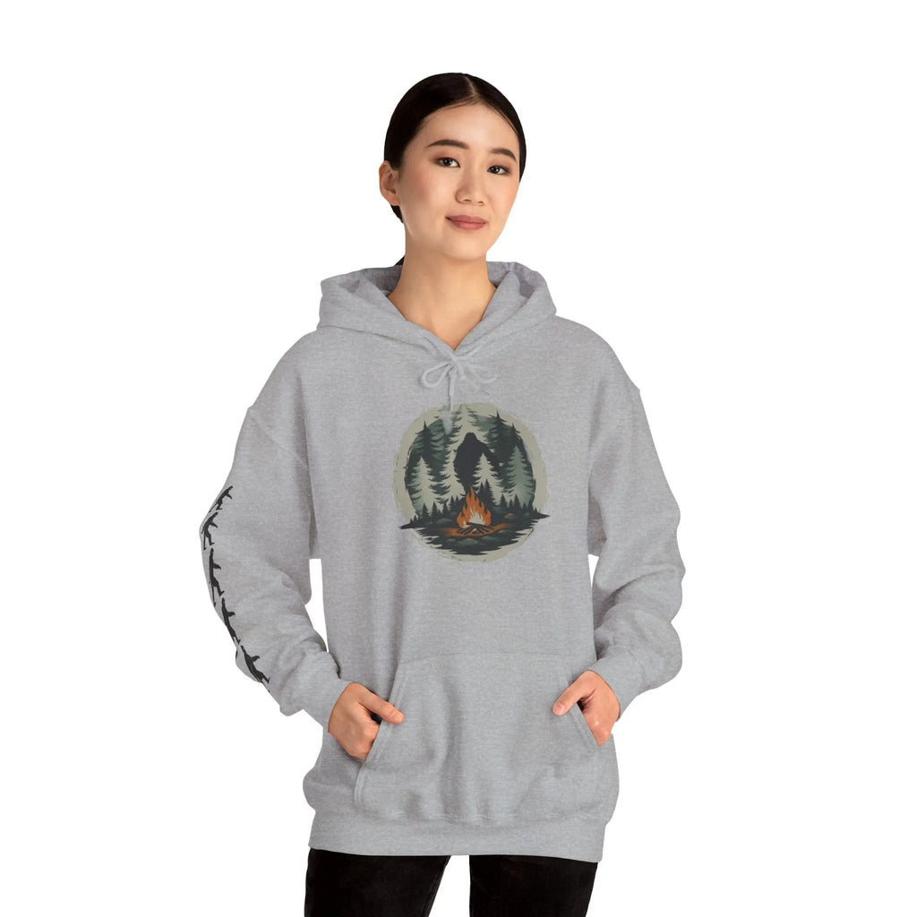 Person wearing a gray hoodie with a nature graphic and black bigfoot silhouettes on the right sleeve on a white background on a white background