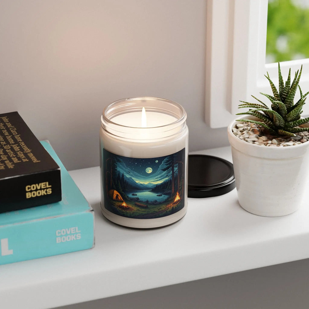 Candle with a scenic label on a shelf next to books and a plant