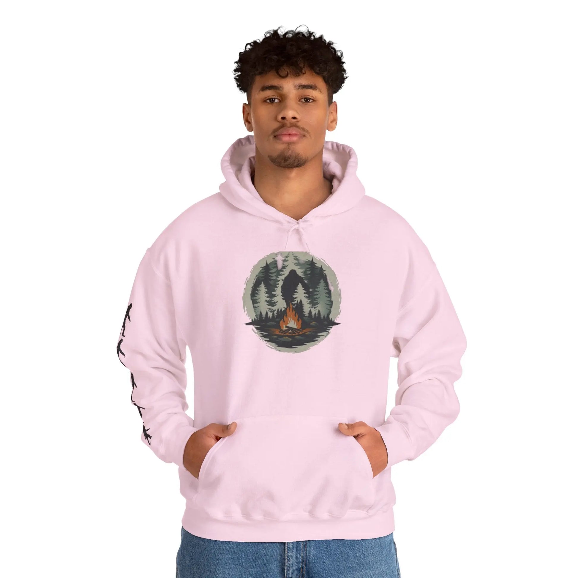 Person wearing a pink hoodie with a nature graphic and black bigfoot silhouettes on the right sleeve on a white background on a white background