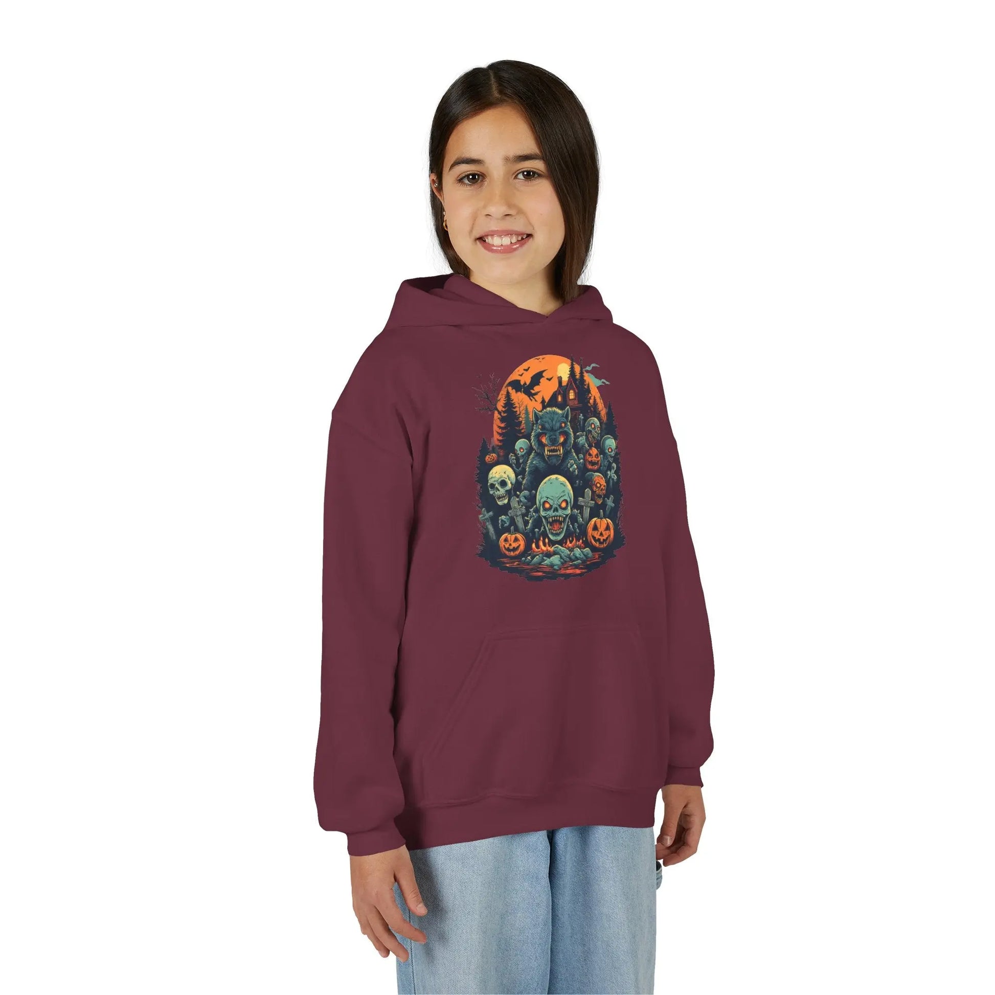 Older child wearing a maroon hoodie with a colorful Halloween graphic design of werewolves, zombies, and other cryptids on a white background