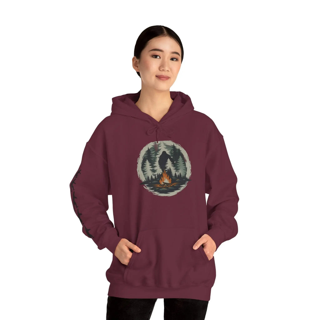 Maroon hoodie with nature graphic and black bigfoot silhouettes on the right sleeve on a white background worn by a model on a white background